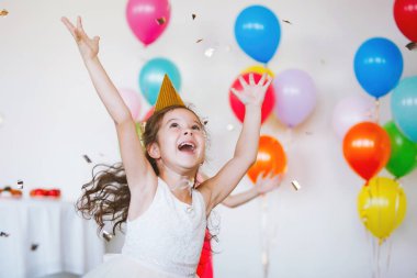 Şapkalı ve şık giysili çocuklar eğlenin ve doğum günlerinin tadını balonlarla çıkarın..