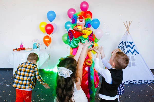 子供たちは遊び 誕生日パーティーでピエロと楽しみます — ストック写真
