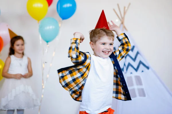 誕生日のお祝いに帽子をかぶった男の子を笑っています 多色気球の背景 — ストック写真