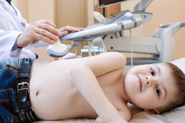 子供の超音波検査 医者は診療所で少年の腹部スキャンを行います — ストック写真