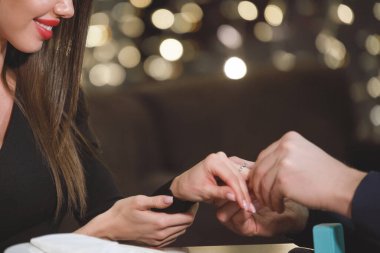 Adam bir kafedeki masada bir kızla evlenmeyi teklif ediyor. Evlilik teklifi. Eller yukarı..