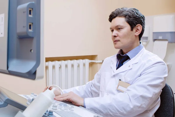 診療所で超音波検査 医者は装置のモニターを調べる — ストック写真