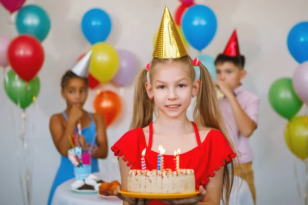 戴着黄色帽子的少女手里拿着蛋糕 庆祝生日 准备吹灭蜡烛 对主要议题的选定重点 — 图库照片