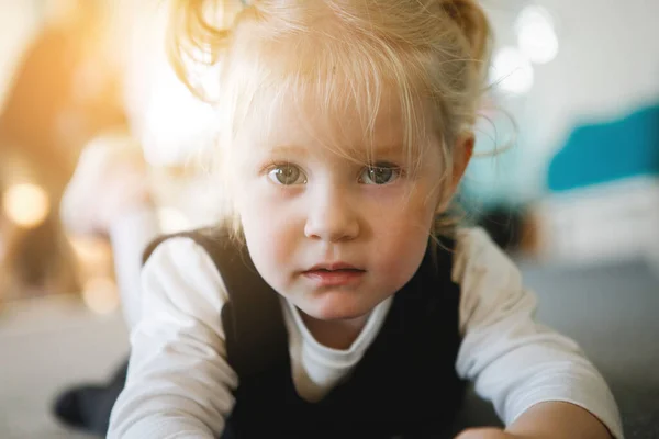 Blond Meisje Met Paardenstaarten Ligt Vloer Poseert Voor Camera — Stockfoto