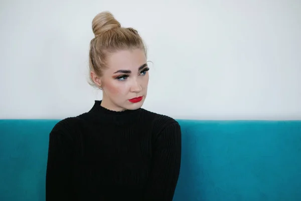 Portrait Une Blonde Assise Sur Canapé Cheveux Réunis Dans Chignon — Photo