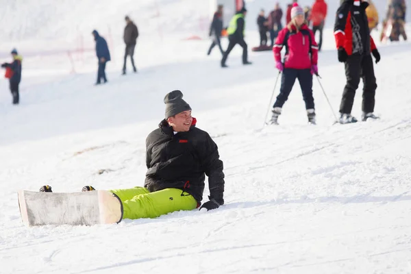 Alpineskiërs Snowboarders Rijden Berg Man Zit Sneeuw Selectieve Focus Wazige — Stockfoto
