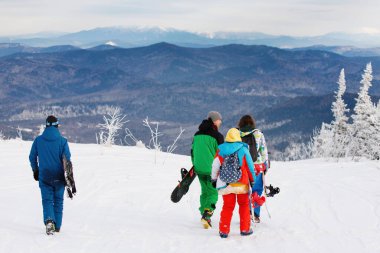 Kar yağışlı bir kış günü bir kayak merkezinde parlak renkli kıyafetli bir grup kaykaycı. Sağlıklı dinlenme kavramı. Aktif hayat. Seçici odaklanma, bulanık arkaplan. 14 / 11 / 2020 Sheregesh, Rusya