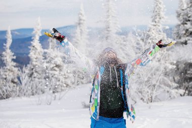 Parlak renkli kıyafetli kaykaycı, karlı kış mevsiminde bir kayak merkezinde poz veriyor. Sağlıklı dinlenme kavramı. Aktif hayat. Seçici odaklanma, bulanık arkaplan. 14 / 11 / 2020 Sheregesh, Rusya