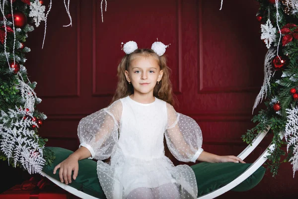 Menina Branco Senta Balanços Arqueados Decorados Com Bolas Natal Ramos — Fotografia de Stock