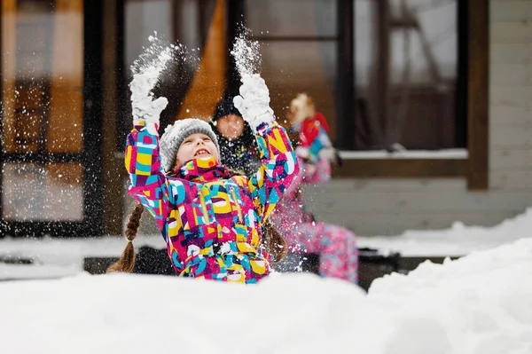 冬の楽しみ レジャー 家族の休暇のコンセプト ピグテールの女の子は 家庭や家族の窓の前で雪のドリフトをスローします 選択的焦点 ぼやけた背景 — ストック写真