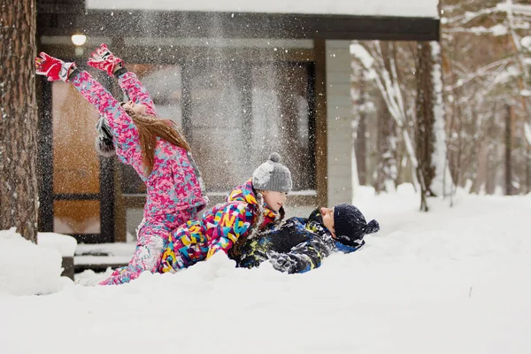 家族のお母さん お父さん 家の近くの冬の森の中で雪と遊んでいます — ストック写真