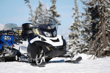 Karlı bir ormanda kar arabası. Arka planda kış süsleri. Seçici odak.