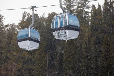 Dağlarda teleferik var. Mavi pencereli kamaralar. Kış köknar ormanı Doğada dinlen. Seçici odak.