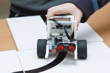 Oyuncak robotları çocukların elleri kontrol eder. Okulda robot laboratuvarı var. Ev yapımı küçük robotların savaşı. Modern teknolojiler. Robot konsepti. Fütürist Bilim Konsepti. Seçici odak.