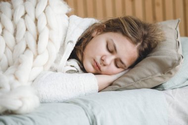 Sarışın kız yastıkta tatlı tatlı uyuyor, elleri başının altında. Seçici odaklanma. Coronavirus karantinası.