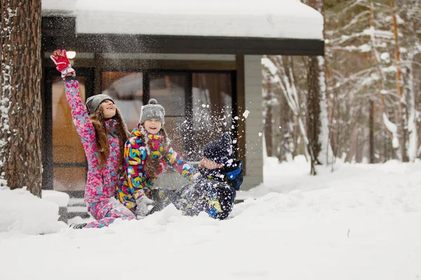 家族のお母さん お父さん 家の近くの冬の森の中で雪と遊んでいます — ストック写真