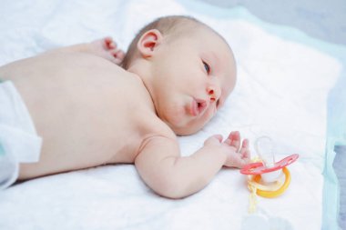 Mavi gözlü yeni doğmuş bir kızın portresi yalan söylüyor ve kameraya bakıyor. Mutlu bir çocukluk. Ebeveyn bakımı.