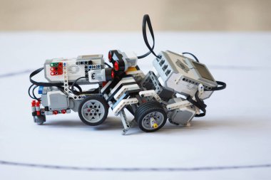 Robot eğitimi. Çocuk kulübünde tekerlekli sandalyeler üzerinde robotların muharebesi. Seçici odaklanma. Beyaz arkaplan.