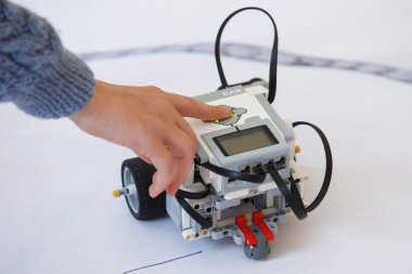 Okulda robot laboratuvarı var. Tekerlekli bloklardan robotların inşaatçılarının savaşı, çocuk el rehberi cihazları. Modern teknolojiler. Robot konsepti. Fütürist Bilim Konsepti. Seçici odak.