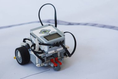 Robot eğitimi. Çocuk kulübündeki tekerlekli bloklardan robot inşaatçıları. Seçici odaklanma. Beyaz arkaplan.