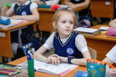 Okul kızları ders sırasında sınıftaki masalarında oturuyorlar. İlköğretim. Seçici odaklanma. Novosibirsk, Rusya, 19.01.2021