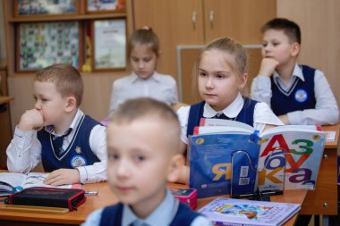 Okul çocukları ders sırasında masalarında oturuyorlardı. İlköğretim. Seçici odaklanma. Novosibirsk, Rusya, 19.01.2021