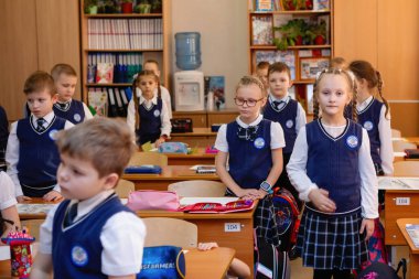 Öğrenciler ders sırasında sınıflarında masalarının arkasında dururlar. İlköğretim. Novosibirsk, Rusya, 19.01.2021