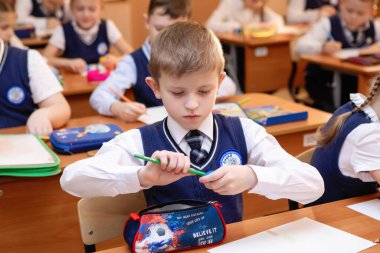 Öğrenci, ders sırasında sınıftaki bir masada oturur. İlköğretim. Seçici odaklanma. Novosibirsk, Rusya, 21.01.2021