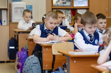 İlkokul öğrencileri sınıftaki masalarında oturuyorlar. Okul eğitimi. Seçici odak.