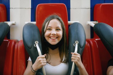 Şehirde yaz eğlence parkında koruyucu maskeli bir kız ya da eğlence parkında. Şehir eğlencesi kavramı, eğlence, eğlence..