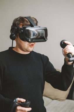 Bilgisayarla oynamak için sanal gerçeklik gözlüğü kullanan genç adam. Genç adam Seçici odak.