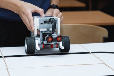 Oyuncak robotları çocukların elleri kontrol eder. Okulda robot laboratuvarı var. Ev yapımı küçük robotların savaşı. Modern teknolojiler. Robot konsepti. Fütürist Bilim Konsepti. Seçici odak.