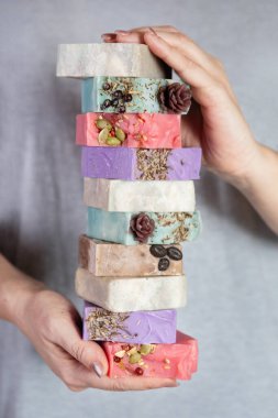 Kadının elinde bir yığın ev yapımı sabun var. Küçük işletmeler, organik ürünler, doğal malzemeler..