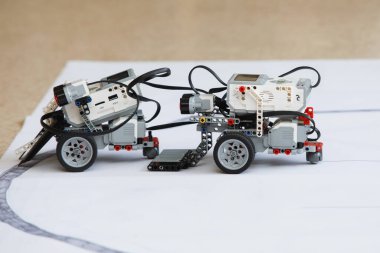Robot eğitimi. Çocuk kulübünde tekerlekli sandalyeler üzerinde robotların muharebesi. Seçici odaklanma. Beyaz arkaplan.