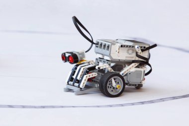 Çocuk kulübündeki robot sergisinde ev yapımı mini robot inşaatçısı. Seçici odaklanma. Beyaz arkaplan.
