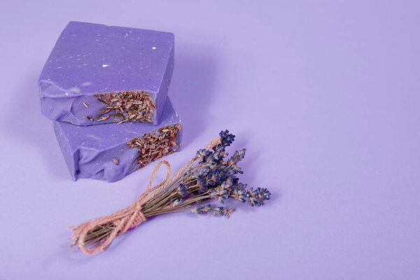 Самодельное мыло ручной работы на фиолетовом фоне. Лавандовый луч. Малый бизнес, органические продукты, натуральные ингредиенты. Вид сверху.