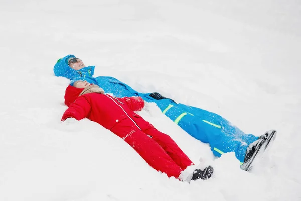 Tata Syn Leżą Śnieżycy Zimowym Parku Ciepłe Niebiesko Czerwone Kurtki — Zdjęcie stockowe