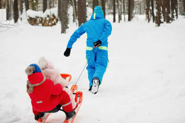 Papa Sleurt Zijn Zoon Dochter Een Snowpark Rode Roze Blauwe — Stockfoto