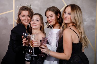 Dört şen giyinmiş kadın Noel 'i bir kadeh şarapla kutluyor. Eğlence, neşe, mutluluk ve kahkaha.