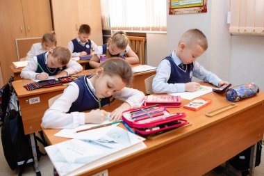 Okul çocukları ders sırasında masalarında oturuyorlardı. İlköğretim. Novosibirsk, Rusya, 19.01.2021