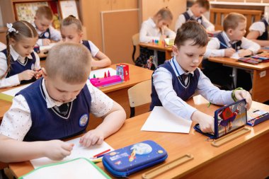 Okul çocukları ders sırasında masalarında oturuyorlardı. İlköğretim. Seçici odaklanma. Novosibirsk, Rusya, 19.01.2021