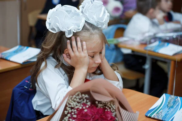 机の上には白い大きな弓を持つおしゃれな服装の女子学生が座っている ノヴォシビルスク ロシア 2020 — ストック写真