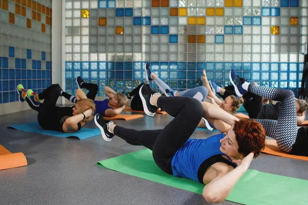 女人在体育馆里做瑜伽或健身垫上的运动 — 图库照片