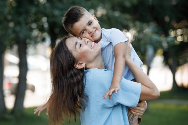 Anne oğluyla birlikte yaz parkında. Seçici odaklanma, bulanık arkaplan. Mutlu bir çocukluk. Ebeveyn bakımı.