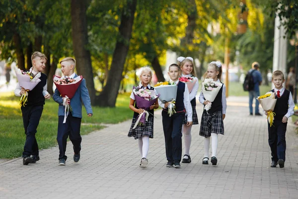 Groep Schoolkinderen Met Bloemen Meisjes Jongens Schooluniformen Lopen Langs Stoep — Stockfoto