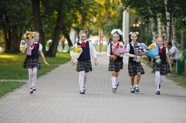 Grupo Escolares Com Flores Meninas Uniforme Escolar Caminham Longo Calçada — Fotografia de Stock