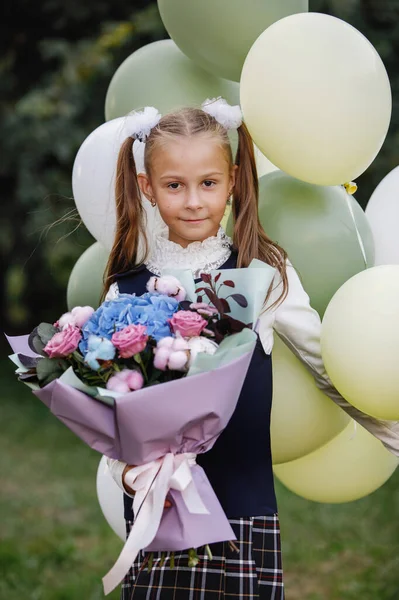 Okul Üniformalı Elinde Çiçekler Balonlarla Yaz Parkında Poz Veren Bir — Stok fotoğraf