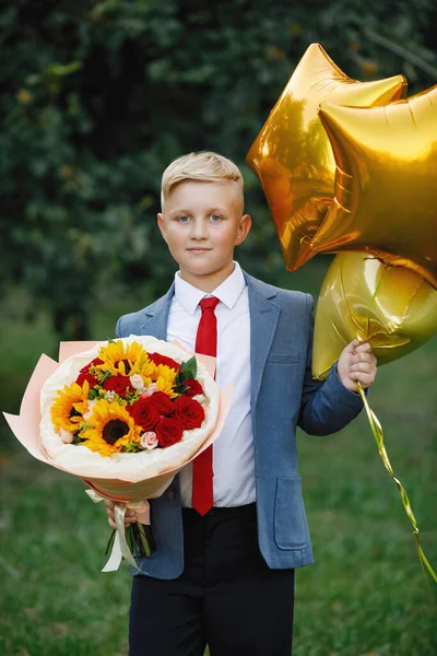 Ragazzo Uniforme Scolastica Con Fiori Palloncini Posa Parco Estivo Focus — Foto Stock