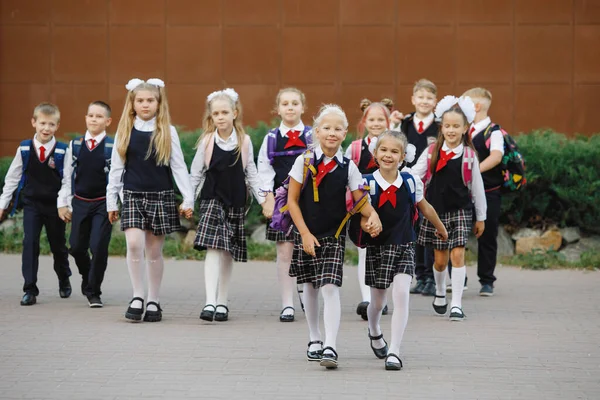 バックパック付きの学校の制服の子供たちのグループは学校に行きます 選択的フォーカス ぼやけた背景 小学校 — ストック写真