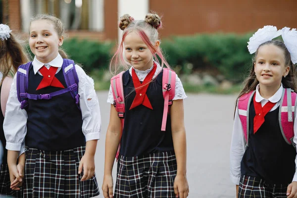 バックパック付きの学校の制服の子供たちのグループは学校に行きます 選択的フォーカス ぼやけた背景 小学校 — ストック写真